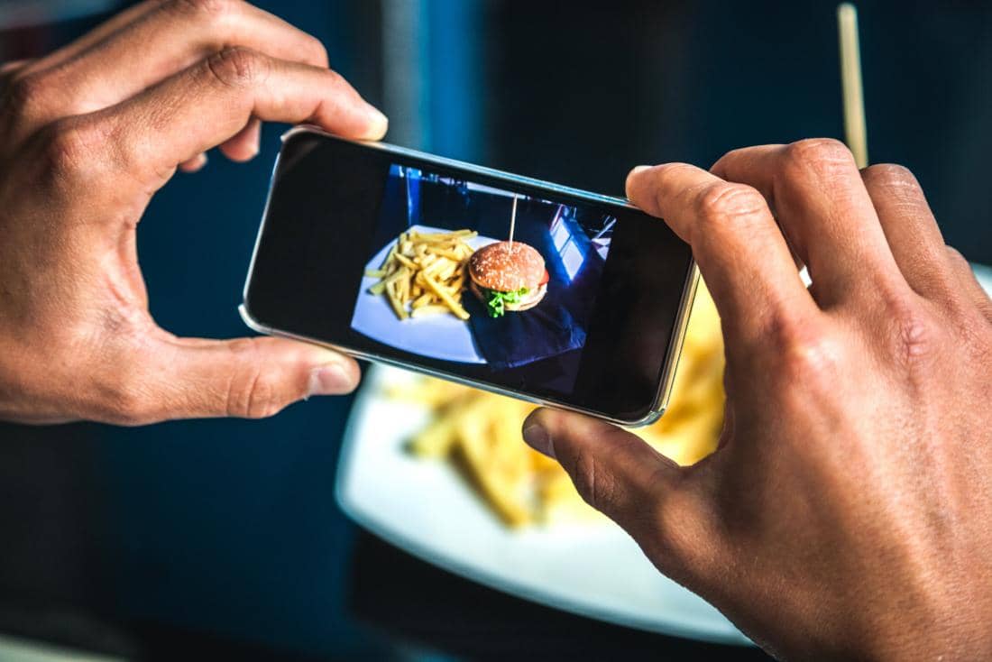 صورة لـ أفضل تطبيقات Android لإقتصاص الصور وتقليل حجمها وأبعادها | person_taking_photo_of_burger_and_fries-Bzp0qOfs-DzTechs