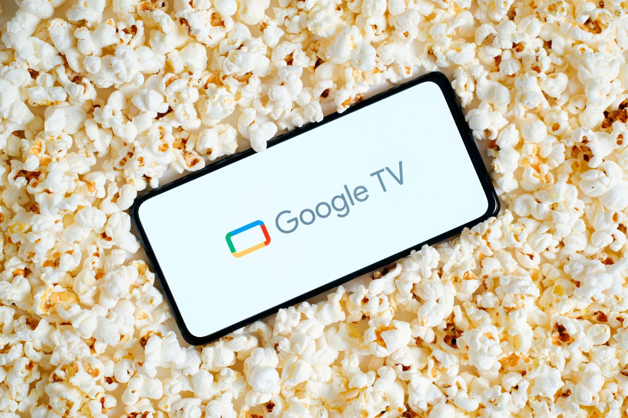 هاتف ذكي يعرض واجهة Google TV مع فشار