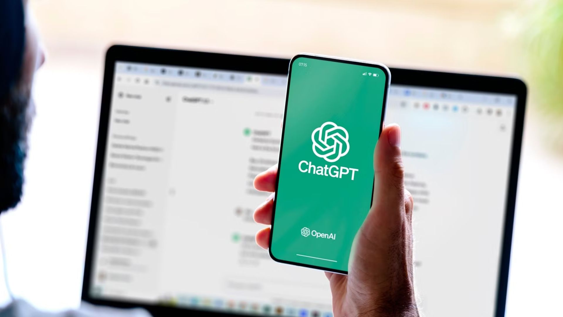 شخص يستخدم ChatGPT على هاتفه الذكي وجهاز الكمبيوتر.