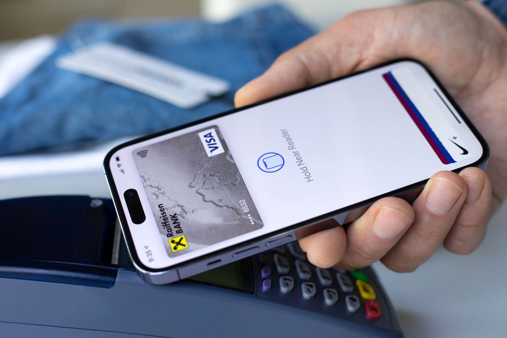 رجل يستخدم Apple Pay على iPhone لإجراء معاملة تجارية