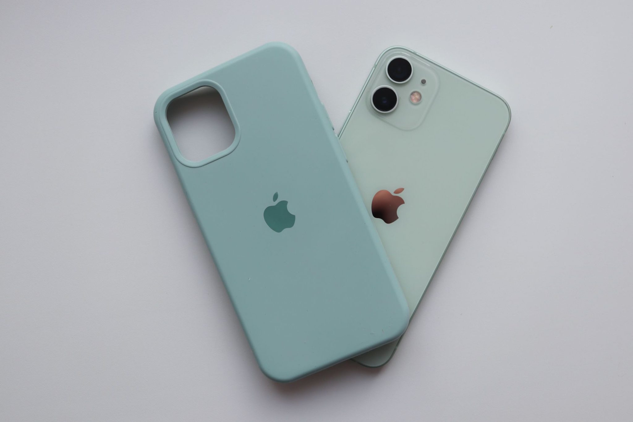 iPhone 12 in pastel green next to Apple Silicone case