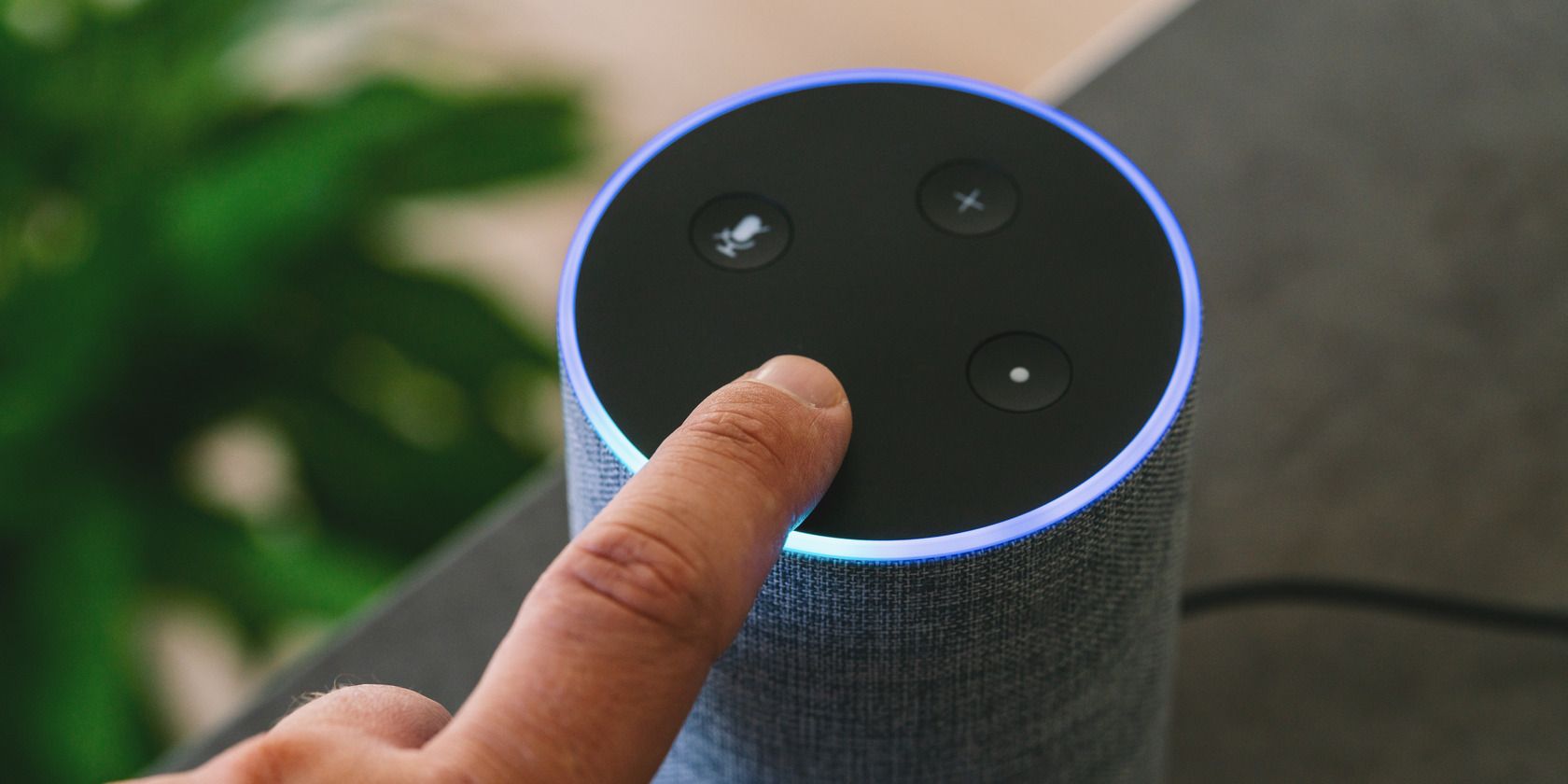 مكبر صوت ذكي من Amazon Echo مع إصبع شخص يضغط على زر في الجهاز