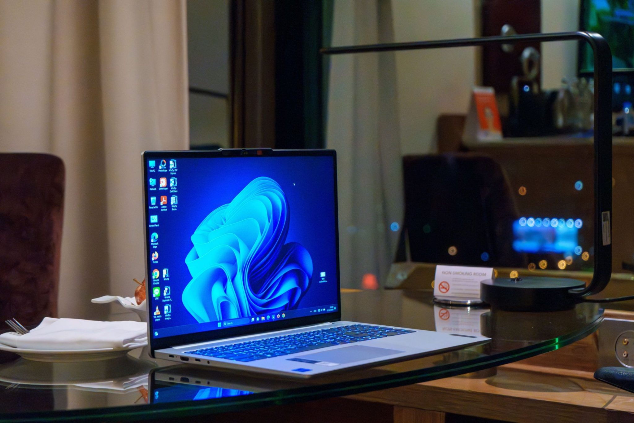 Windows laptop on glass table with icons on desktop